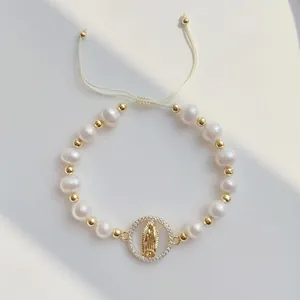Detailed view of handmade natural pearl bracelet with gold Virgin Mary pendant charm