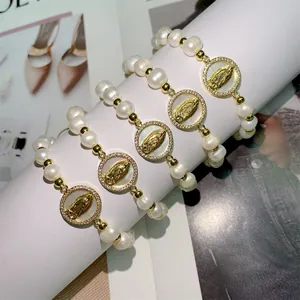 Detailed close-up of handmade natural pearl bracelets with shell Virgin Mary charms.