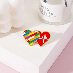 Detailed view of rainbow and heartbeat double heart enamel pin on white background
