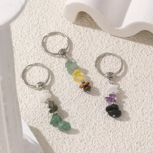 Natural crystal stone chip keychains with silver alloy floral beads on stone background