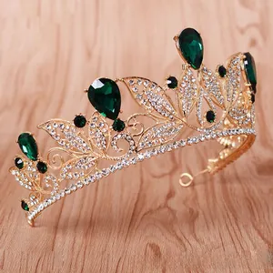 Close-up of a baroque style golden bridal crown featuring emerald green rhinestones