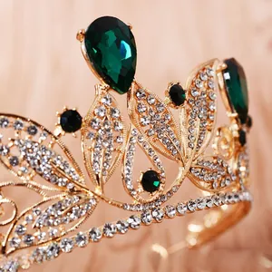 Detailed view of a gold Baroque crown with emerald crystals and clear rhinestones