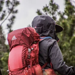 Close-up of crystal gravel keychain attached to a red hiking backpack outdoors