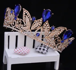 Side view of intricate vintage gold crown featuring large blue teardrop crystals