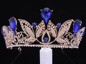 Detailed view of a gold bridal crown with large blue teardrop crystals and white rhinestones