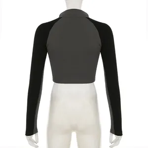 Back view of a grey and black color-block cropped long sleeve polo top on a mannequin