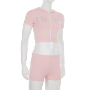 Detailed view of pink two-piece sports set featuring 1995 rhinestone hoodie and shorts
