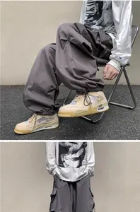 Detail view of grey vintage techwear cargo pants with drawstring cuffs on male model