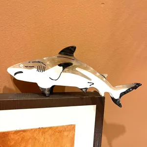 Close-up detail of a shark-shaped acetate hair claw clip with black and white patterns