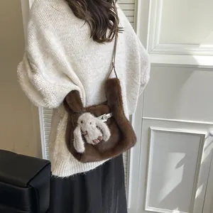 Close-up of brown plush handbag featuring cute bunny charm and silver buckle detail.
