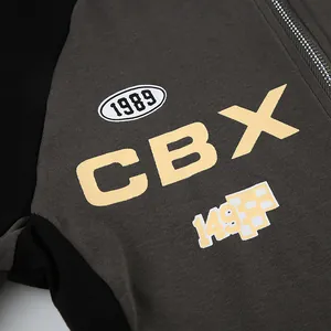 Close-up of street style zipper top with yellow CBX letter print and contrast colors.