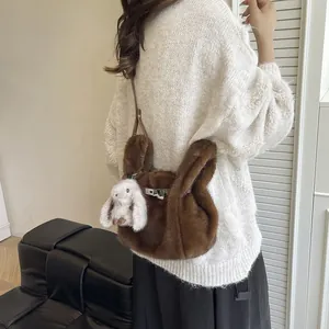 Back view of a fluffy brown plush shoulder bag with a cute white rabbit keychain charm.