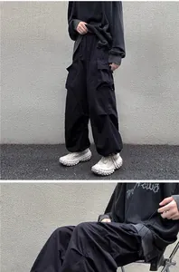 Close-up of black vintage cargo pants featuring tactical pockets and adjustable drawstring cuffs.