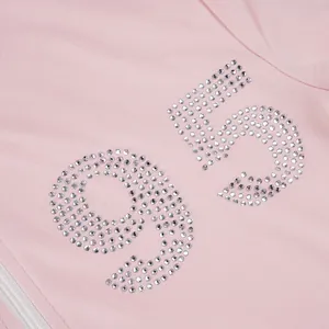 Detailed close-up showing the sparkling rhinestone number 95 on pink tracksuit fabric