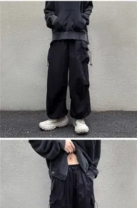 Detail view of men's vintage black cargo pants with drawstring waist and adjustable cuffs.