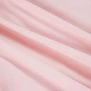 Macro detail of soft pink fabric texture showing elegant pleats and delicate weave