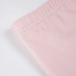 Close-up macro detail of pink elastic waistband with fine double stitching on soft fabric