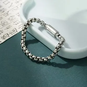 Primo piano del bracciale a catena a osso di drago argentato con chiusura a cilindro