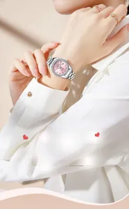 Detail shot of elegant silver women's quartz watch with pink rhinestone dial on wrist