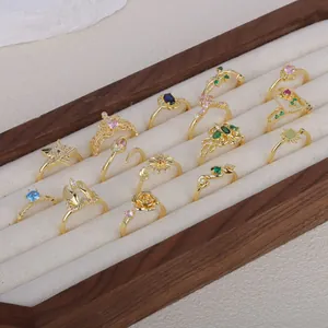 Collection of vintage French gold plated adjustable rings displayed in a luxury wooden tray
