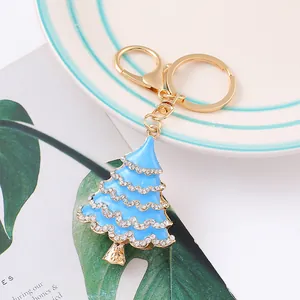 Detail of a light blue enamel Christmas tree keychain with crystals and gold hardware.
