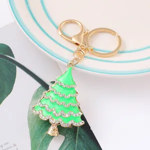 Close-up of green enamel Christmas tree keychain decorated with sparkling rhinestones