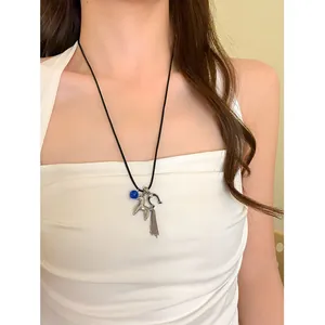 Detailed view of vintage horse necklace with blue bead and silver tassel on model