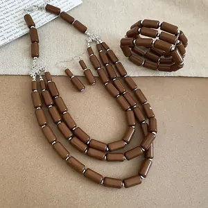 Close-up of brown cylindrical agate necklace, bracelet, and earrings jewelry set