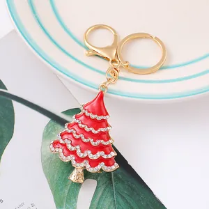 Close-up detail of red enamel Christmas tree keychain with sparkling rhinestones.