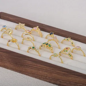Variety of vintage gold-plated rings with colorful stones in a wooden display box.