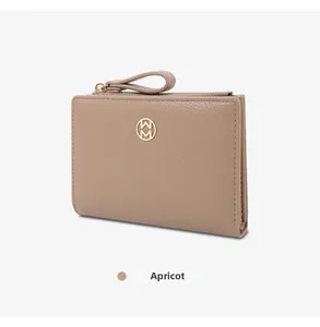 Elegant apricot grained leather bi-fold wallet for women with a gold logo detail.