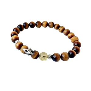 Natural tiger eye and rutilated quartz bead bracelet with a silver star charm on white