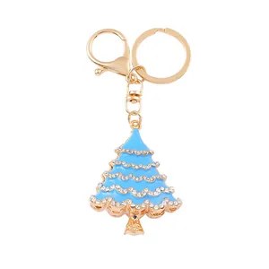 Close-up view of light blue enamel Christmas tree keychain with sparkling rhinestones