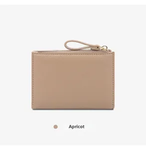 Close-up detail of apricot minimalist bifold leather wallet with zipper pull loop