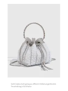 Macro view of elegant pearl and rhinestone bucket evening bag with silver tassel detail