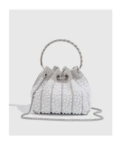 Detail shot of luxury pearl evening bucket bag with crystal accents and chain strap