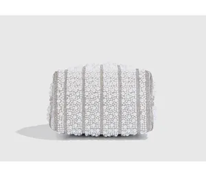 Macro detail of high-end evening clutch bag featuring elegant white pearls and rhinestones.