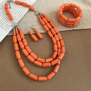 Detailed macro view of vibrant orange layered bead necklace, matching bracelet and earrings.