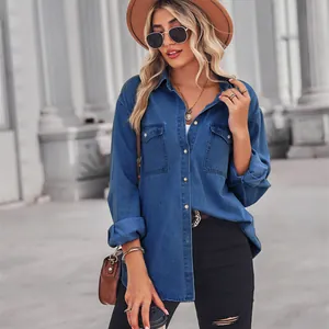 Detailed view of a stylish women's long-sleeve blue denim shirt with lapel and twin pockets