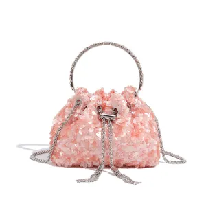 Close-up of shimmering pink sequins and silver ring handle on this luxury evening bag.