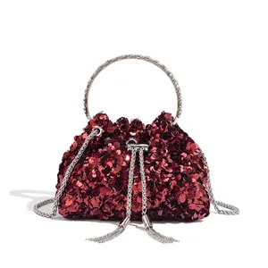 Close-up of red sequined evening bucket bag with silver tassels and ring handle