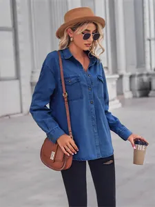 Woman wearing a stylish light blue denim long sleeve shirt with classic lapel and pockets