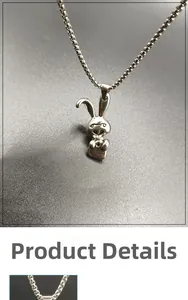 Macro view of a silver-toned stainless steel necklace featuring a grumpy rabbit pendant