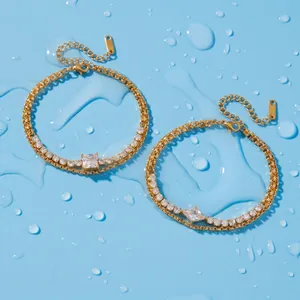 Close-up of double-layered gold-plated bracelets with cubic zirconia on blue surface