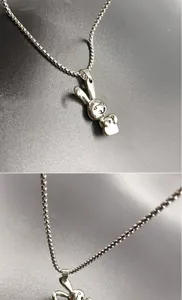 Detail view of silver stainless steel rabbit pendant and durable box chain texture