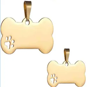 Close-up of polished golden bone-shaped pet ID tags featuring a hollow paw print design