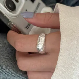Vista macro di un anello in argento irregolare con trama in lamina fatta a mano
