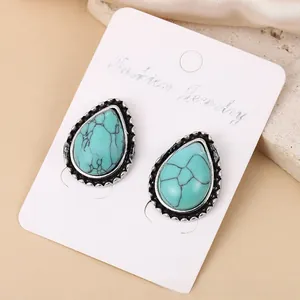 Vintage turquoise druppelvormige legering oorknopjes gepresenteerd op witte sieradenkaart.