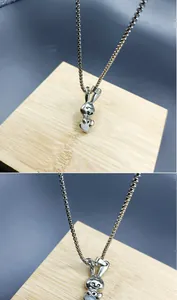 Detailed macro view of a stainless steel rabbit pendant with a classic box chain