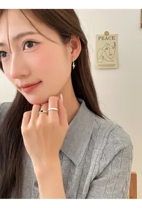 Detailed shot of a woman wearing gold-plated sparkling lightning bolt hoop earrings
